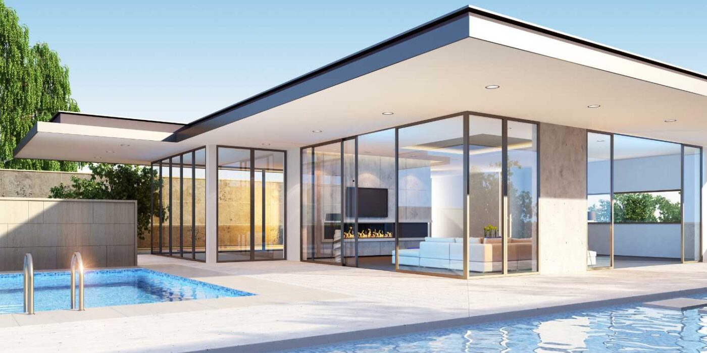 Modern villa with a flat roof, floor-to-ceiling glass walls, a swimming pool, and a light-colored patio on a sunny day.